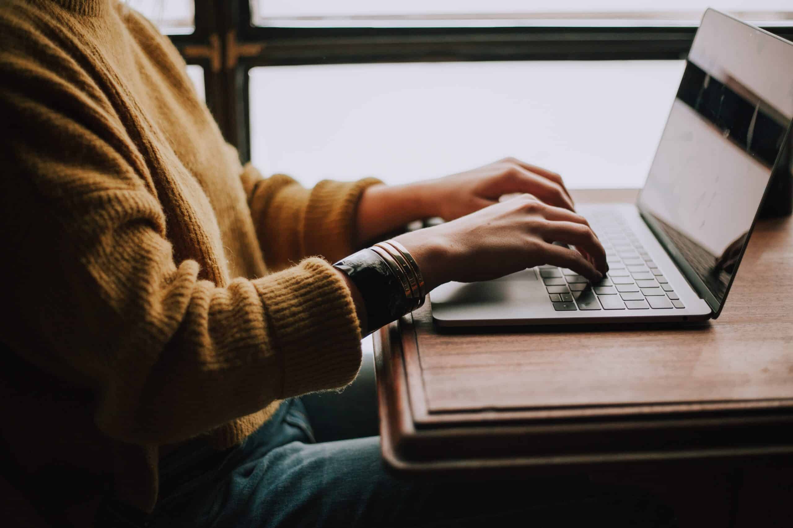 man typing in front of his laptop