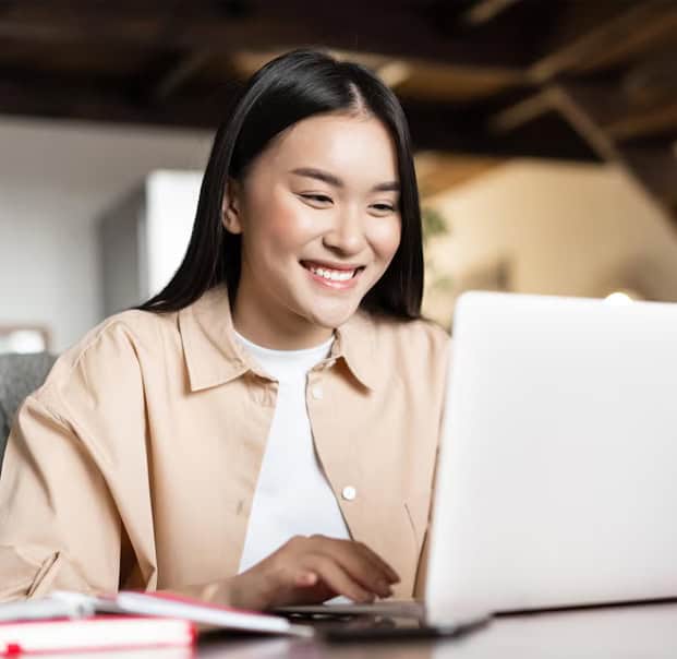 Lady smiling in front of a laptop happily working